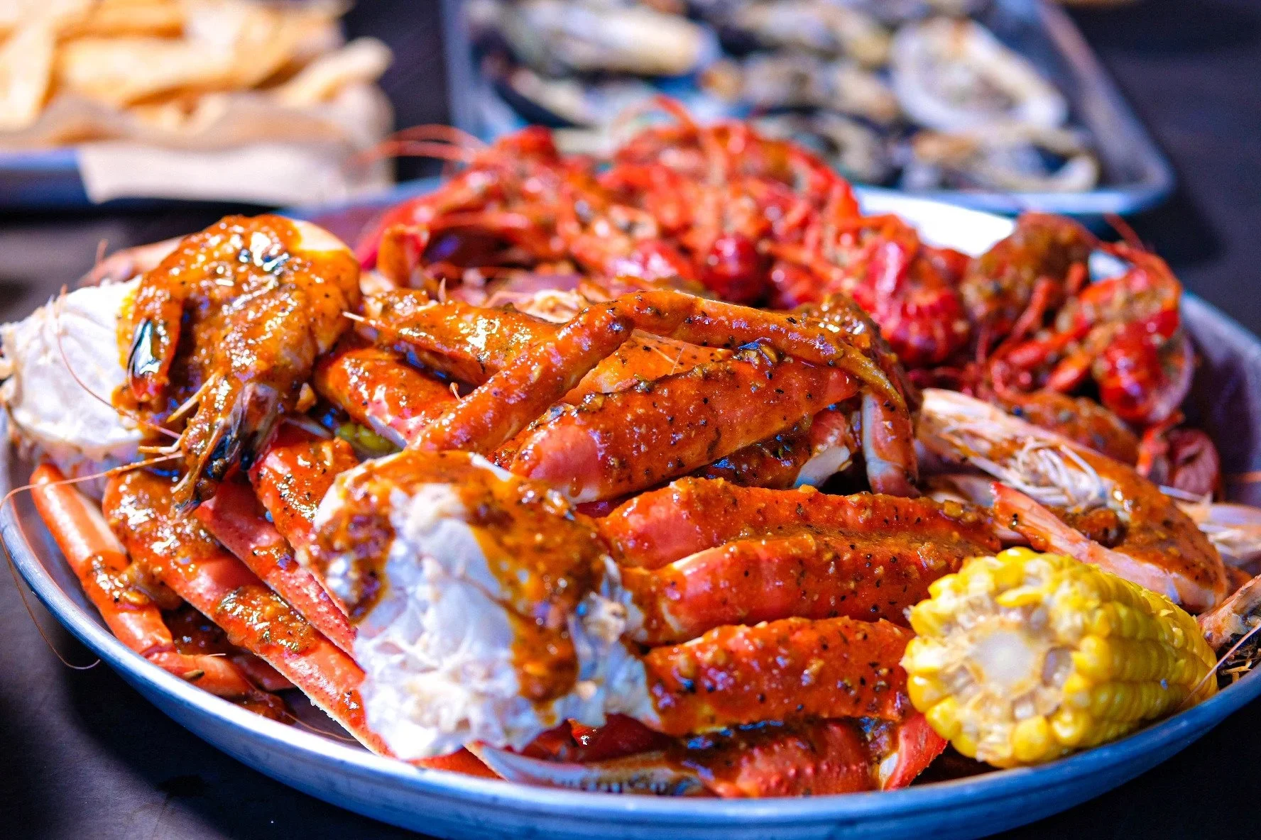 Seafood platter with crab legs, shrimp, and a piece of corn on the cob.