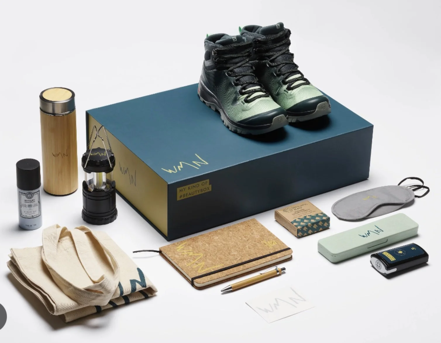 Au lieu des traditionnels produits de beauté, la #WMNbeautybox propose des produits réellement utiles pour les sportives (magnésie, lumière, gourde) et la nouvelle paire de chaussures de randonnée de la marque