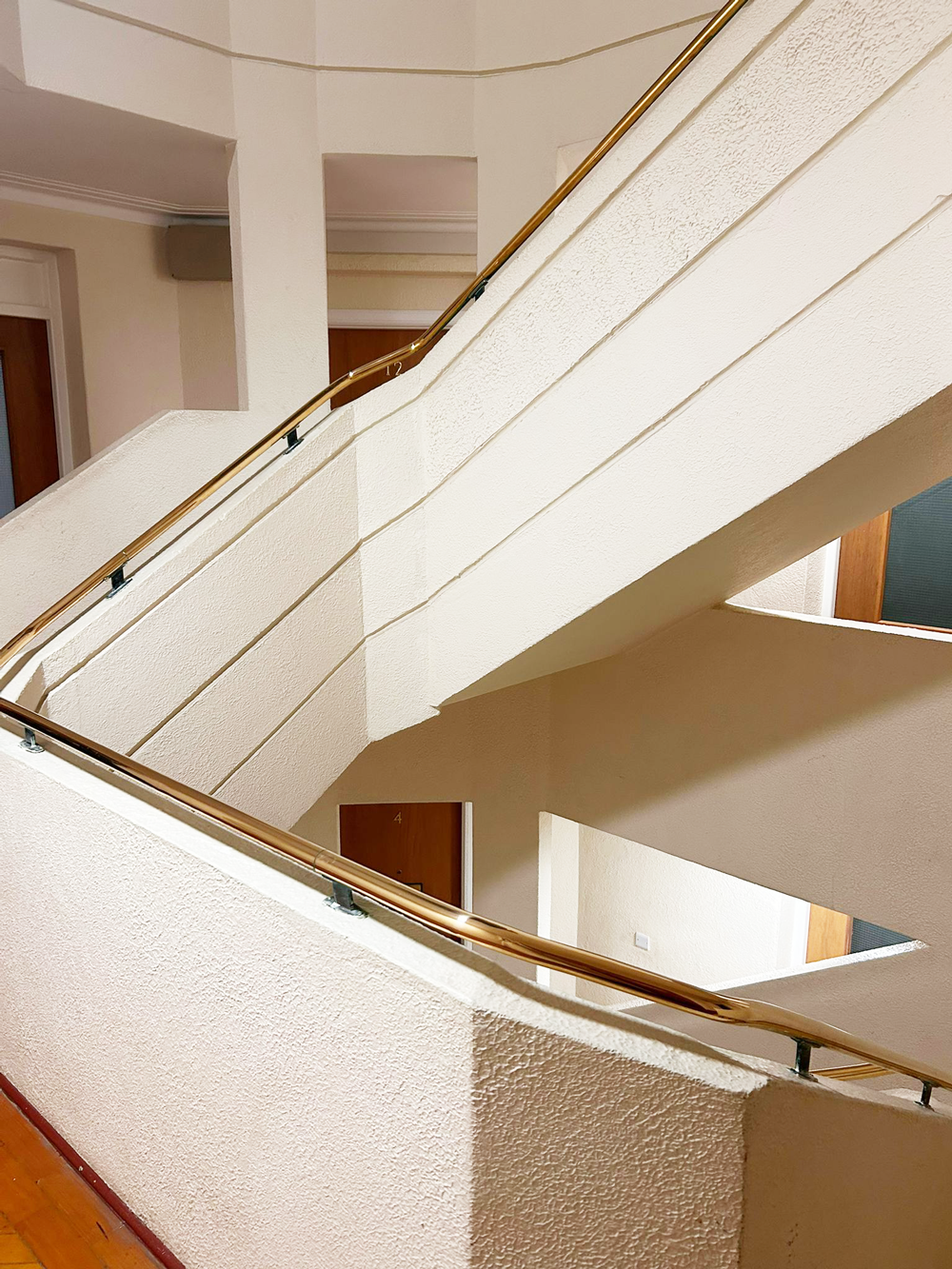 A staircase with a gold handrail inside the apartment building.