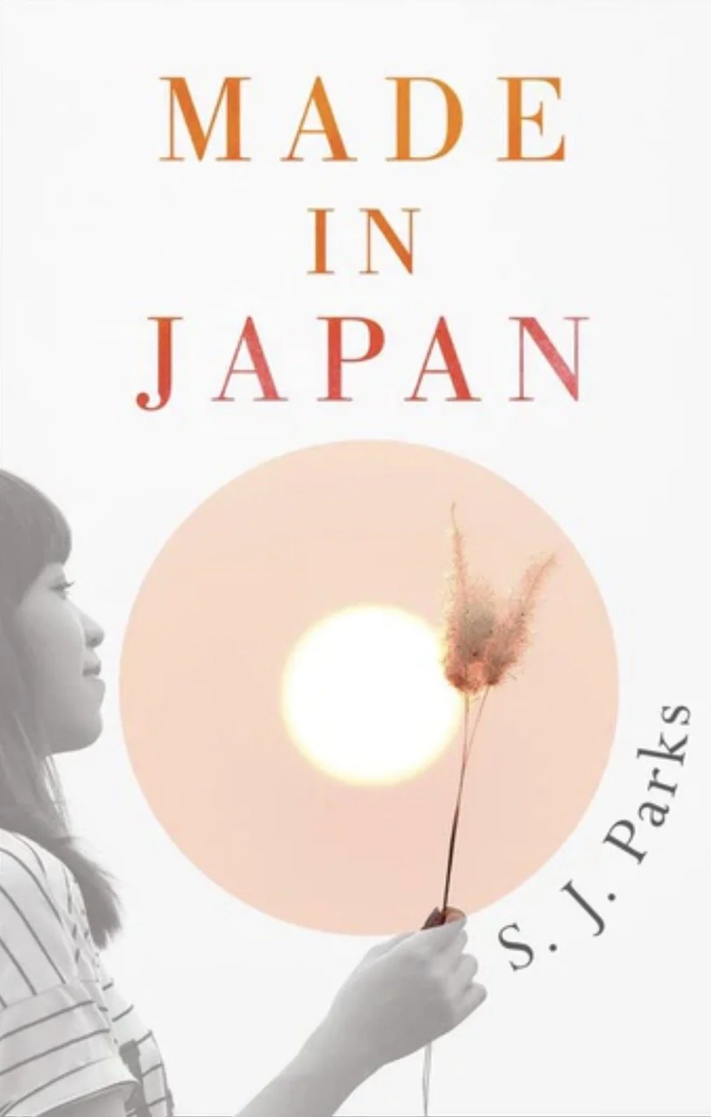 Book cover titled 'Made in Japan' by S. J. Parks, featuring a grayscale image of a woman holding a stick with a fluffy pink feather, against a white background with a pinkish circle and a bright light