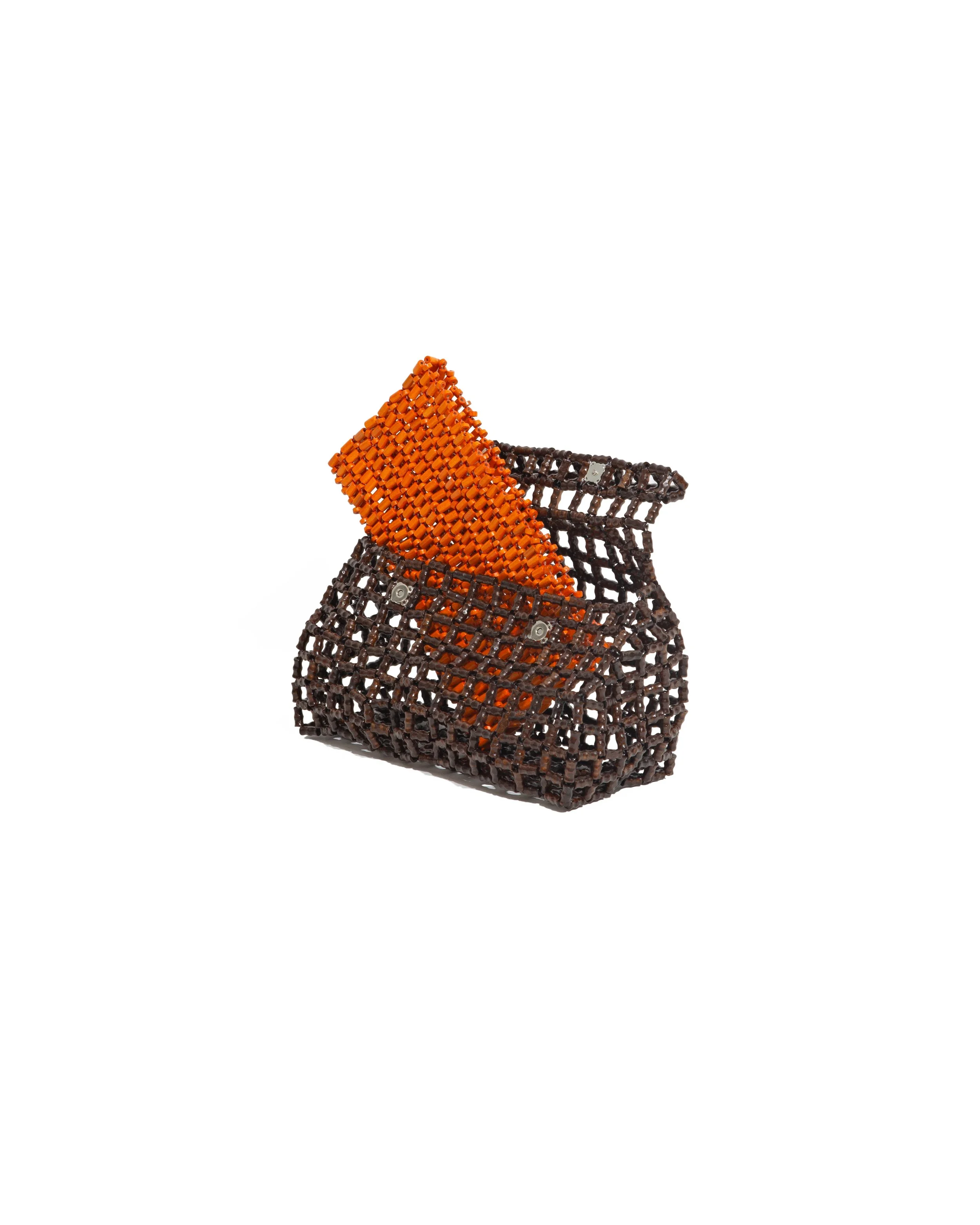 A small black lattice bag holding an orange rectangular object with a textured surface.