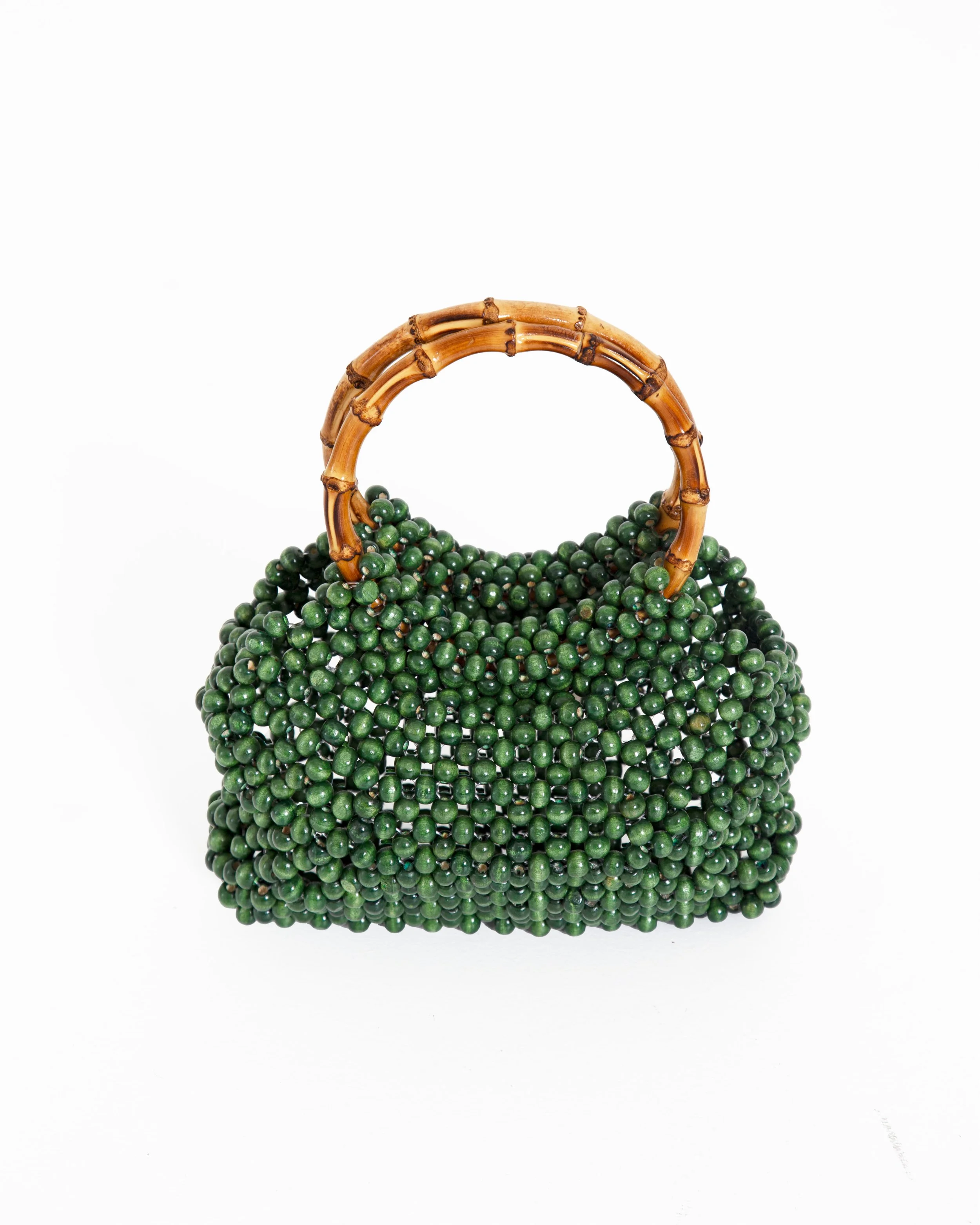 Green beaded handbag with bamboo handle, set against a white background.