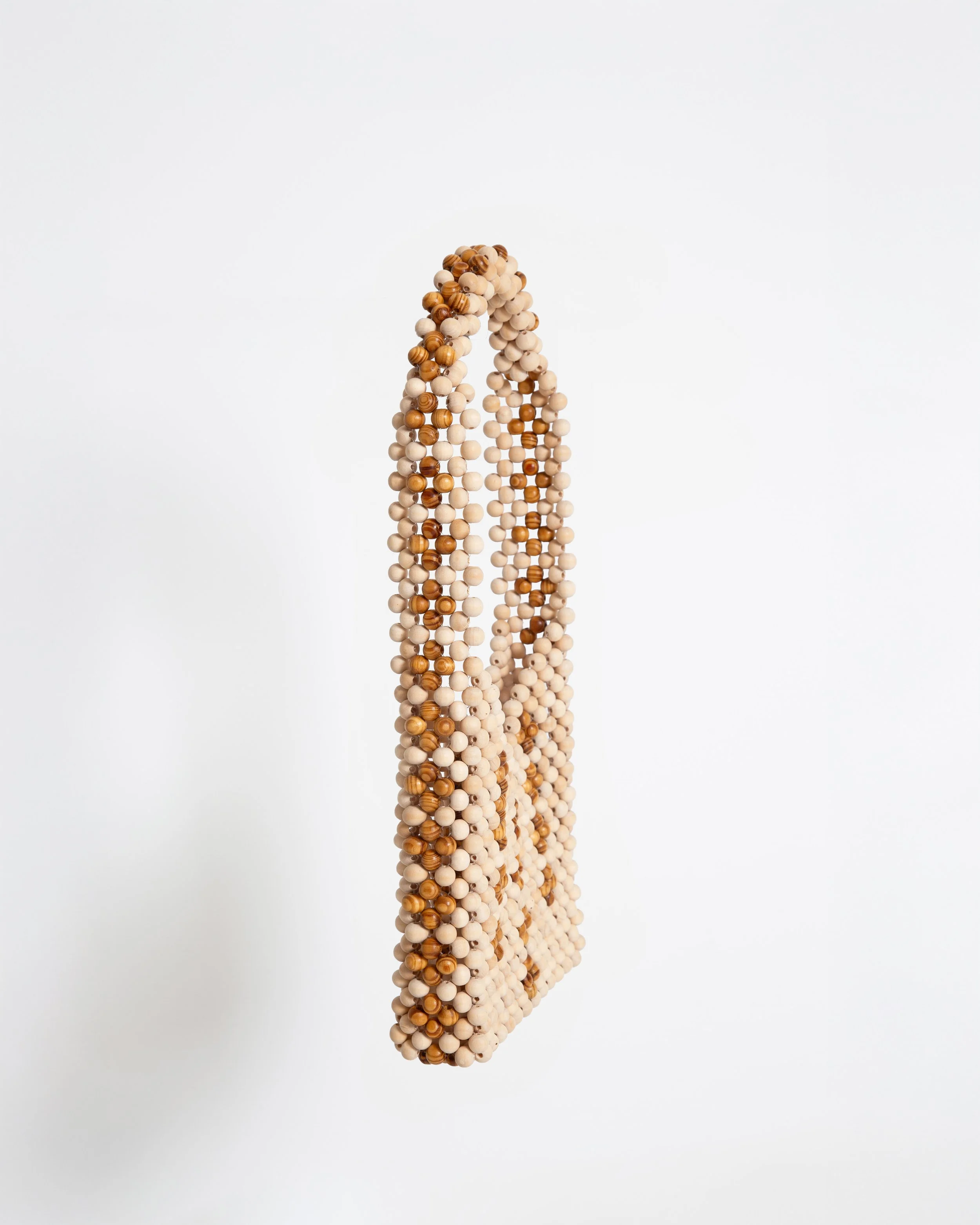 Beaded tote bag with beige and brown round beads hanging against a plain white background.