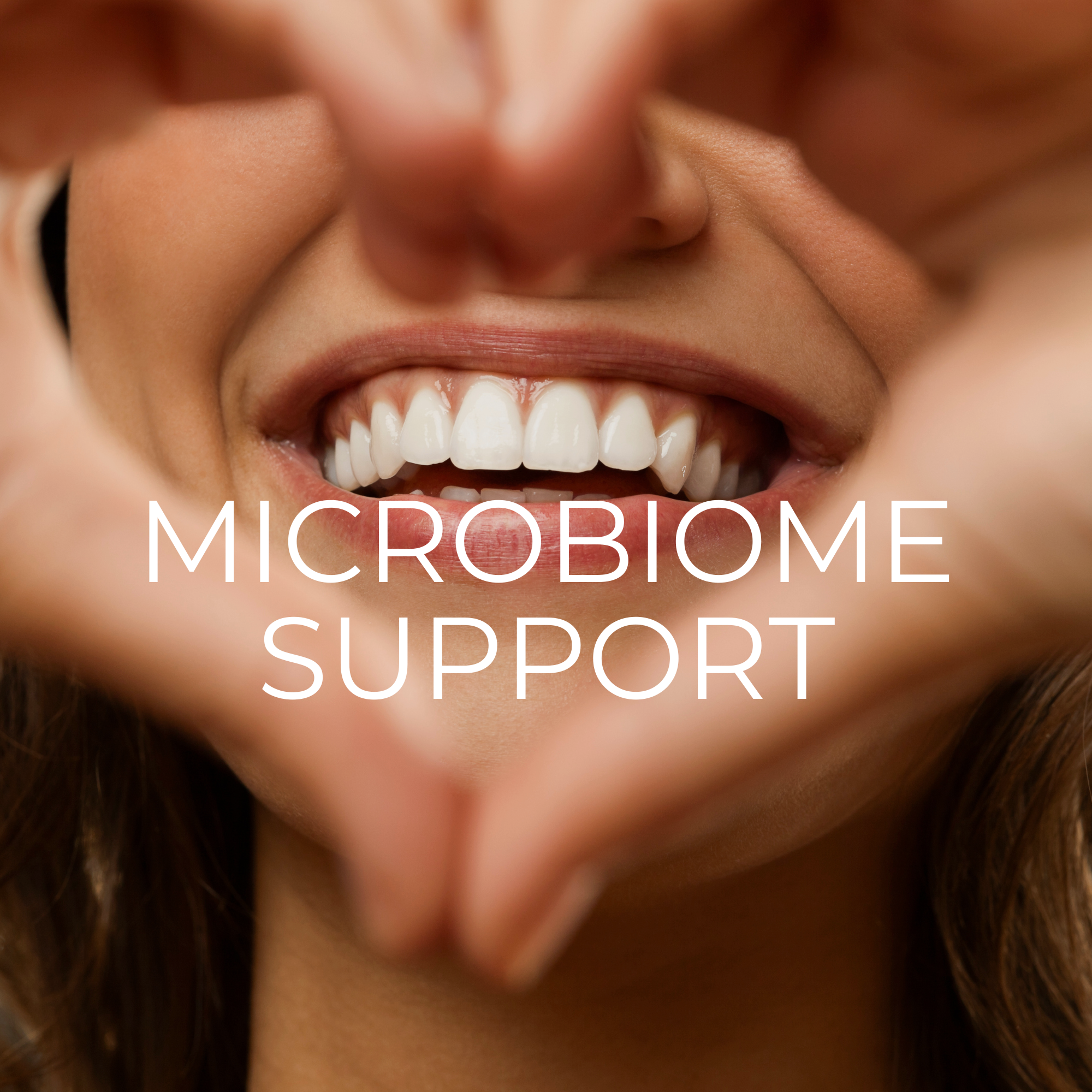 Close-up of a smiling woman with white teeth, visible gums, and brown hair, with the words 'Microbiome Support' overlaid.