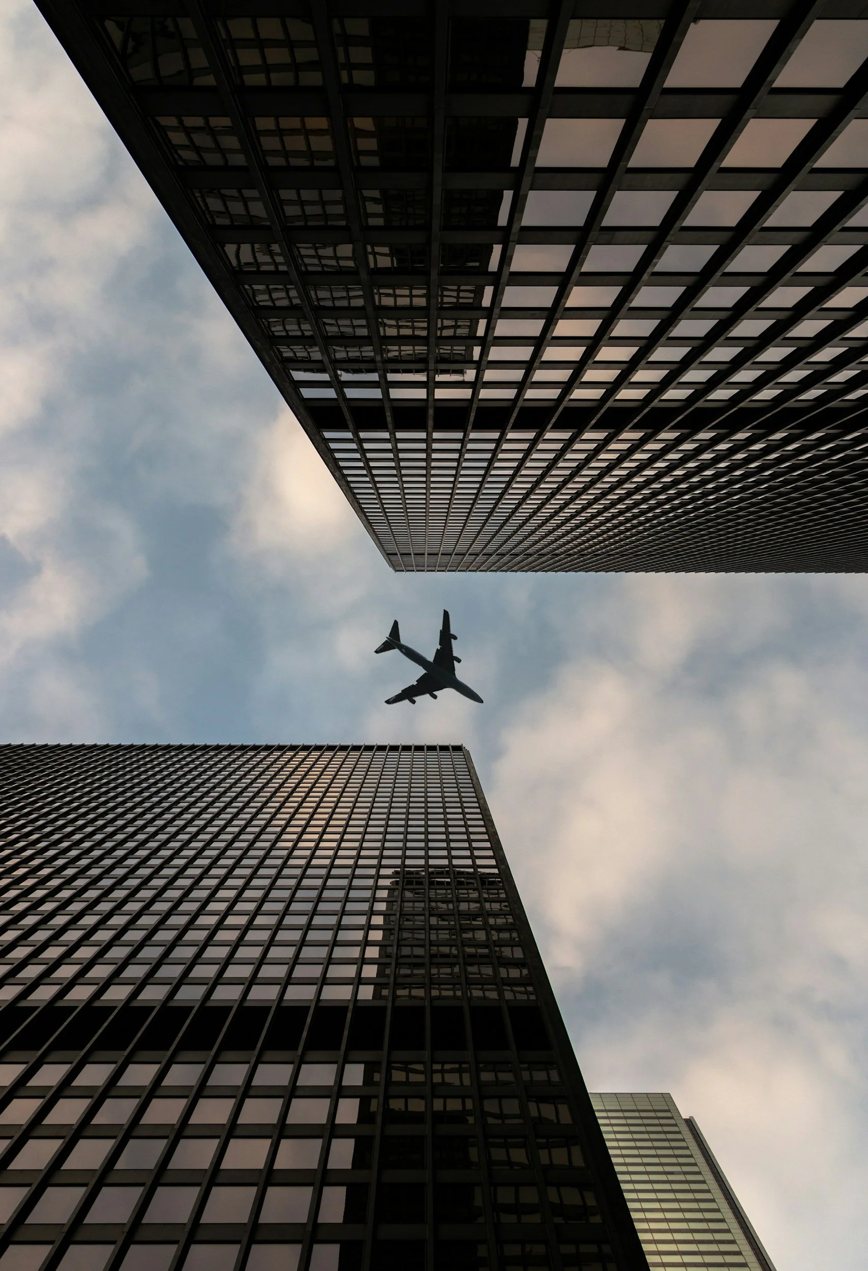 A plane flying between skyscrapers illustrating DeGroot Fine Art fine art consulting services delivered confidentially across cities nationwide.