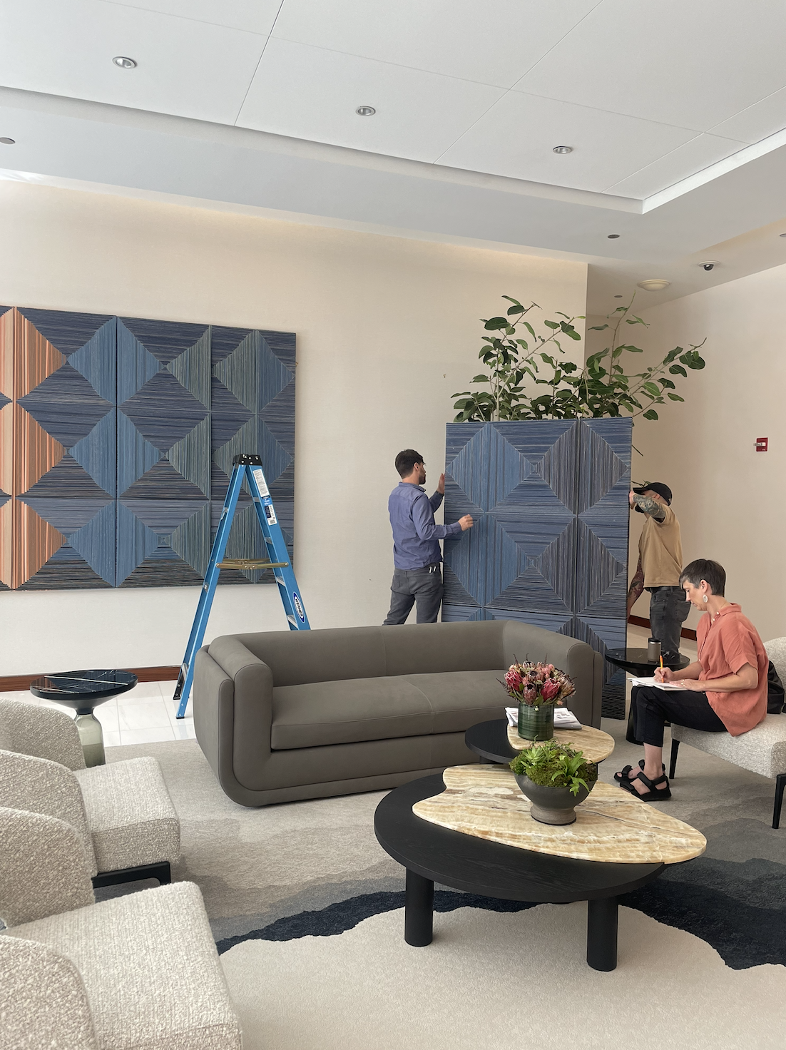 DeGroot Fine Art team installing artwork in a corporate office as part of a fine art consulting engagement.
