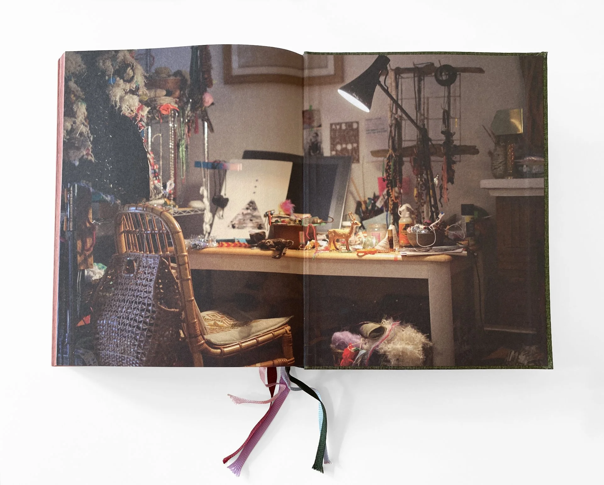 Open magazine showing a cluttered table with various small decorations, a lamp, and a wicker chair in the foreground.