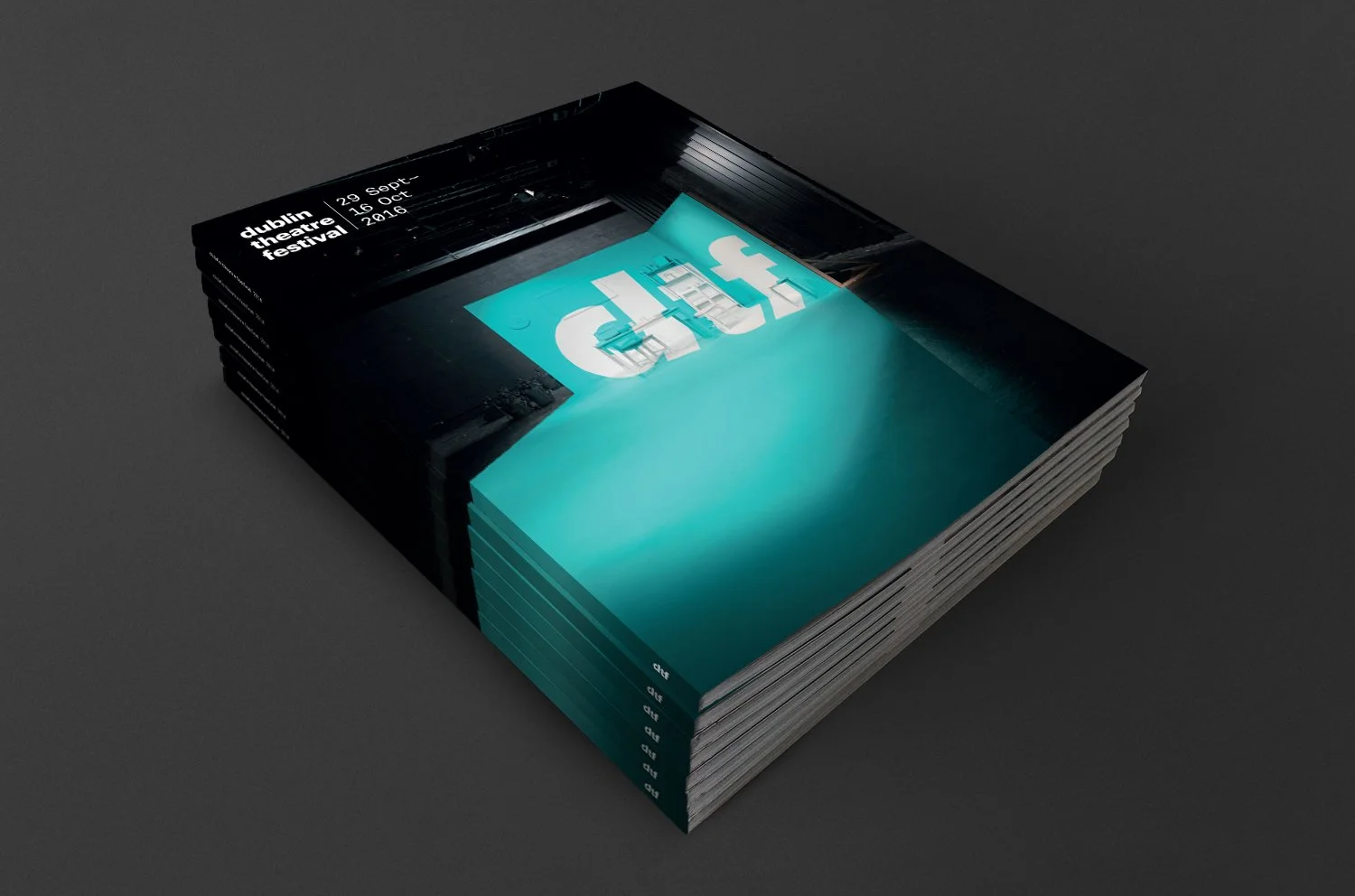 Stack of programs or flyers for Dublin Theatre Festival from September 29 to October 16, 2016, featuring a modern, dark-themed design with a large blue and white logo.