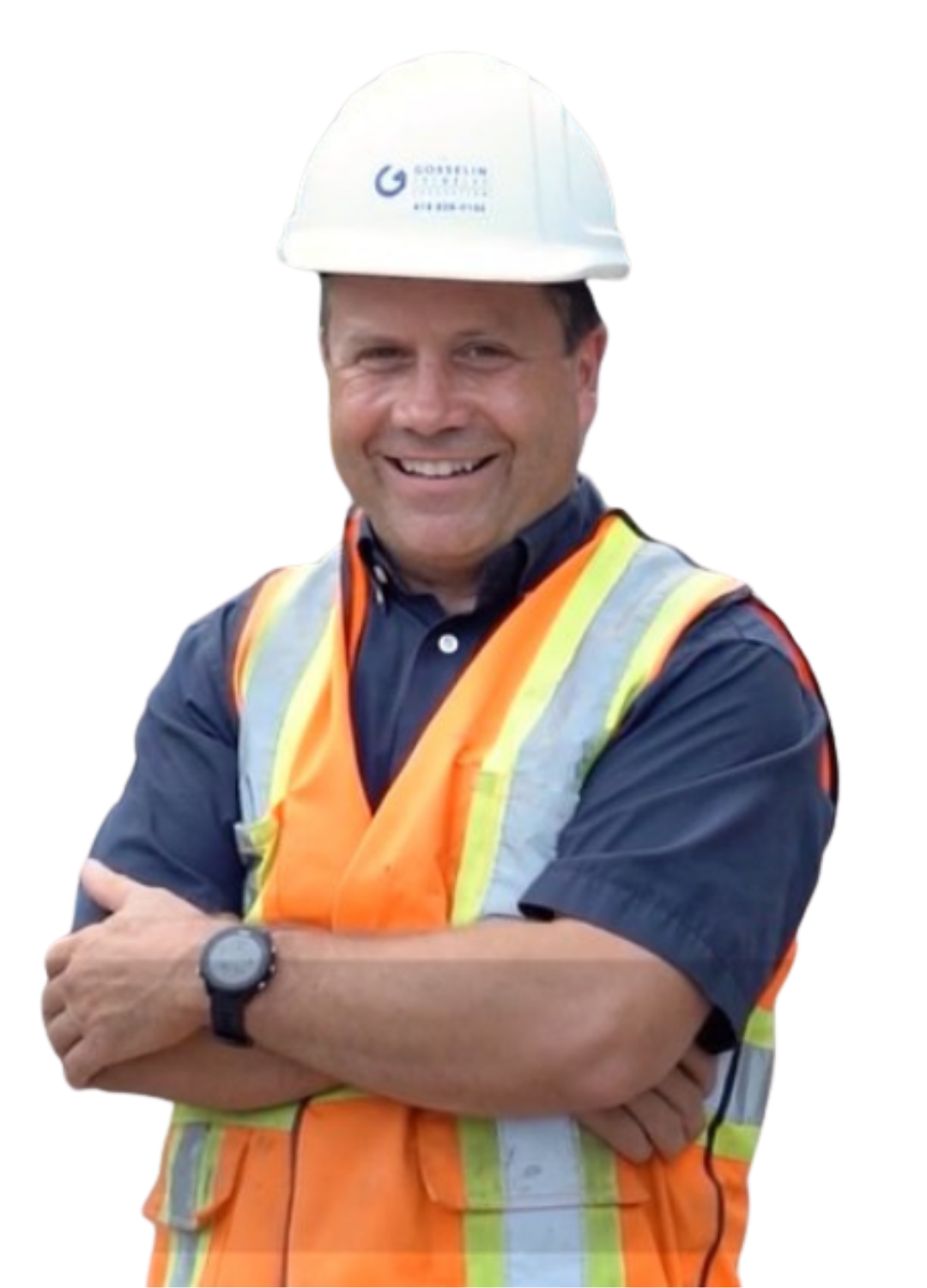 Homme souriant portant un casque blanc avec un logo, un gilet de sécurité orange et jaune, une chemise bleue, et un montre, posé avec les bras croisés.