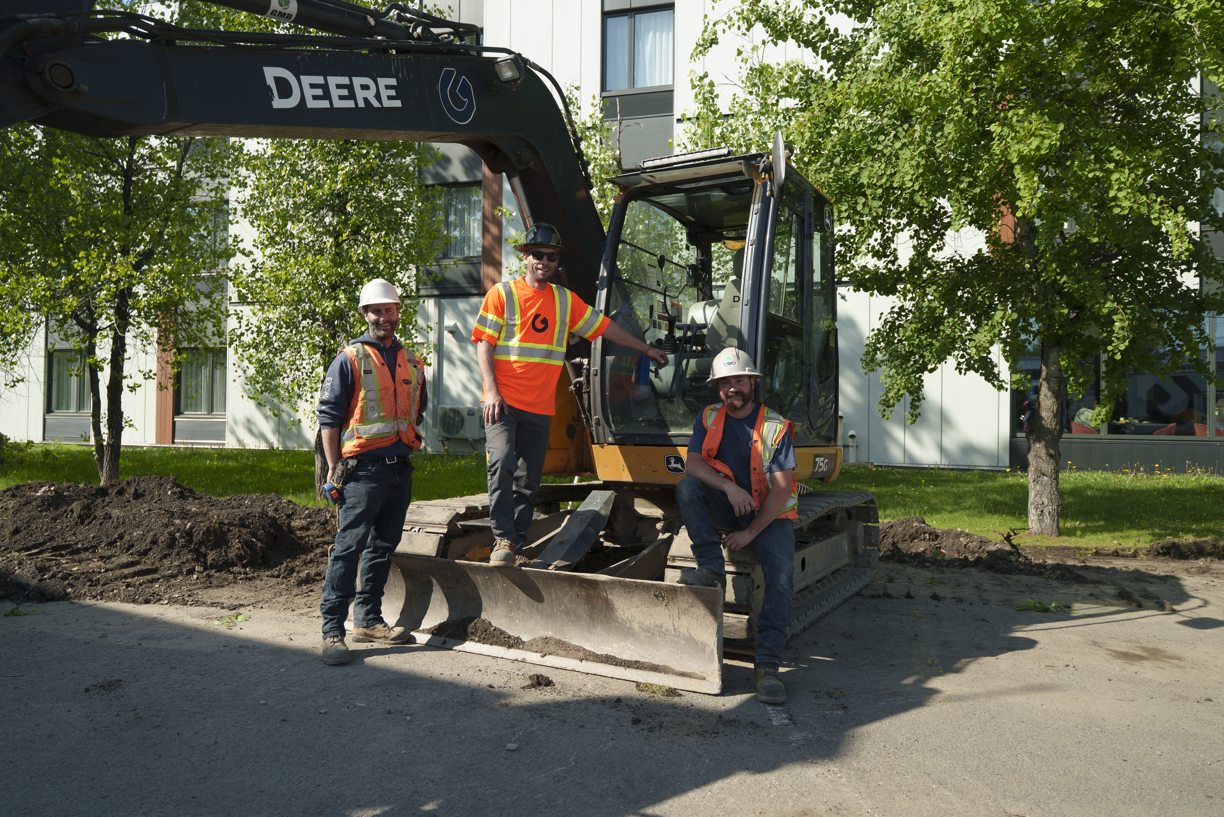 Photo de groupe de l'équipe Gosselin Tremblay Excavation devant la flotte de camions à Québec
