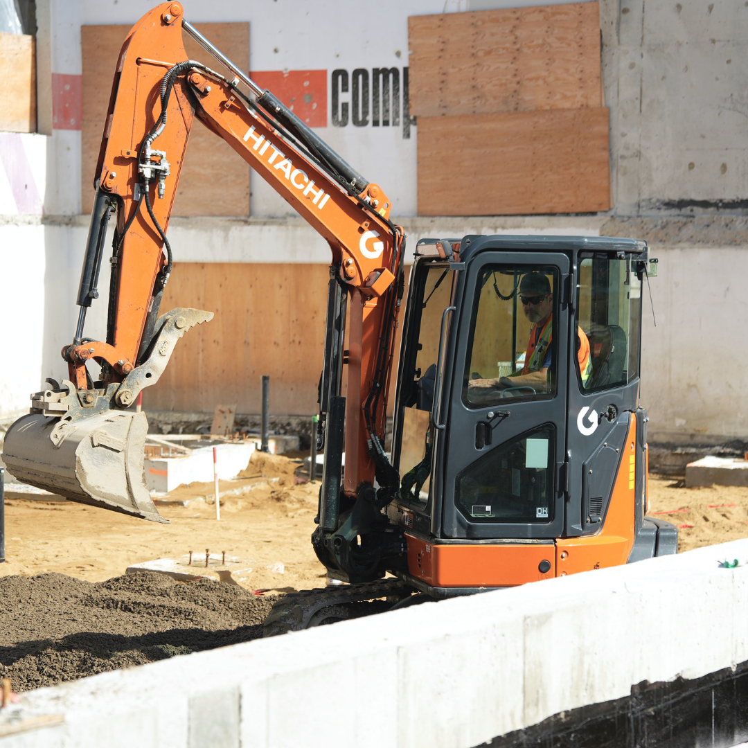 Opérateur de pelle qui travaille avec une Hitachi pour l'agrandissement d'un bâtiment