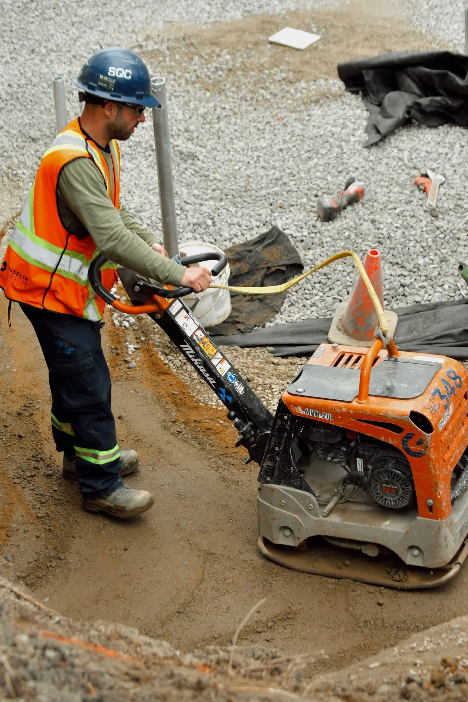 Un manœuvre de Gosselin Tremblay Excavation utilise un compacteur pour solidifier le sol.