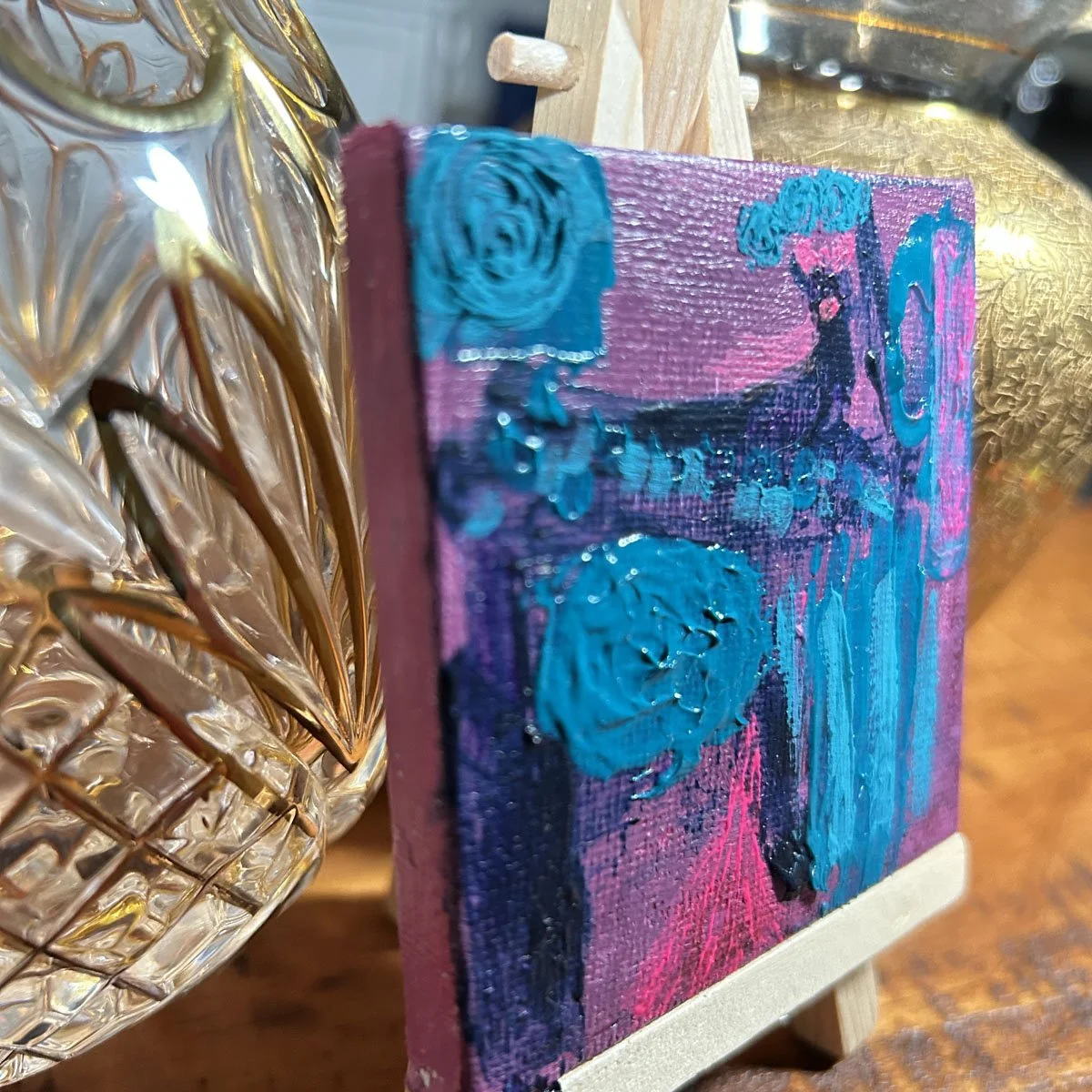 Side profile view of mini canvas showing thick teal and dark blue textured impasto paint details