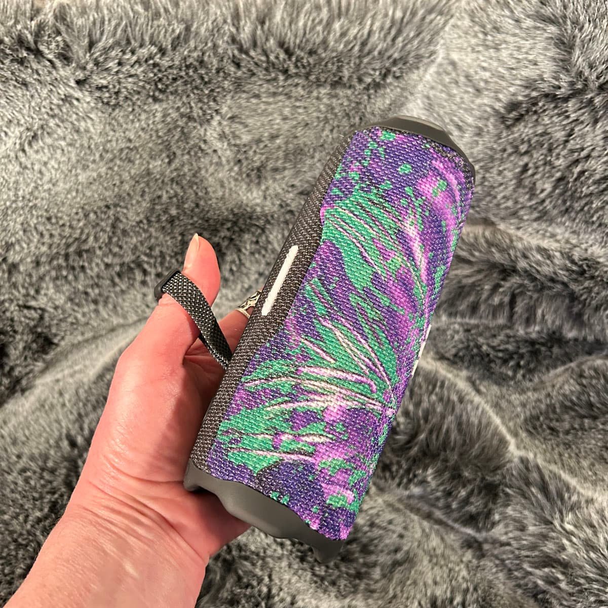 The back view of a portable device showcasing the seamless application of the "Controlled Chaos" green and purple abstract art skin by Heather Collis Design.