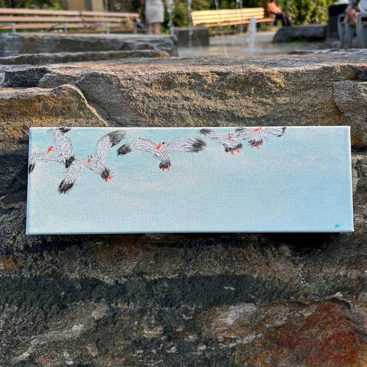 Painting of seagulls flying above the ocean in a blue sky by Heather Collis