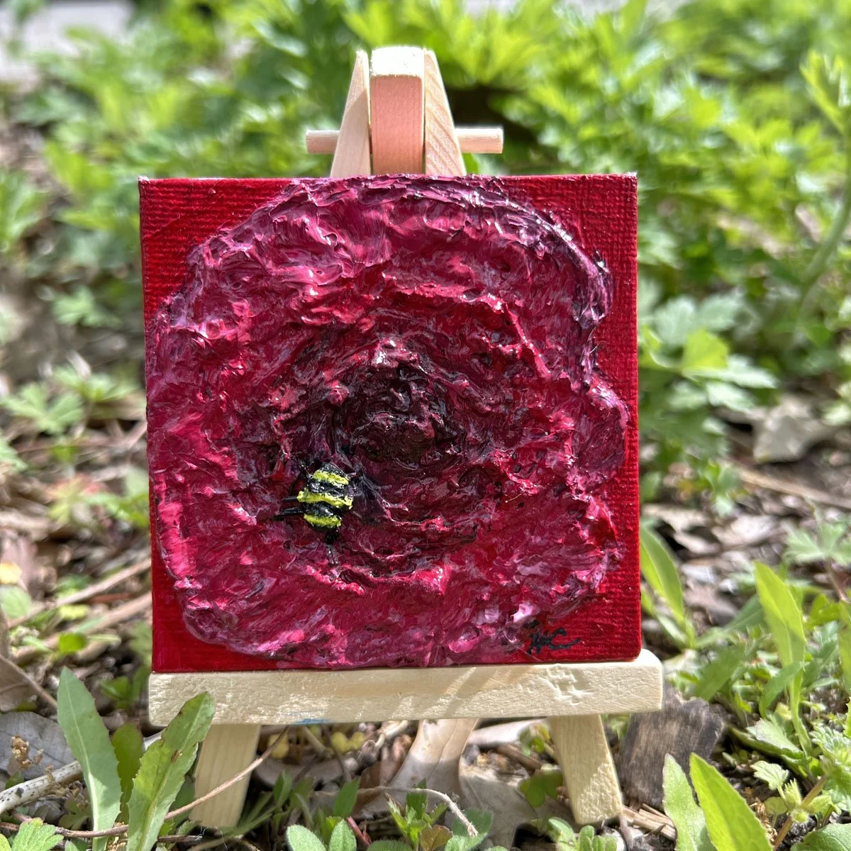 Bumblebee and a red rose spring flowers and nature at work on easel