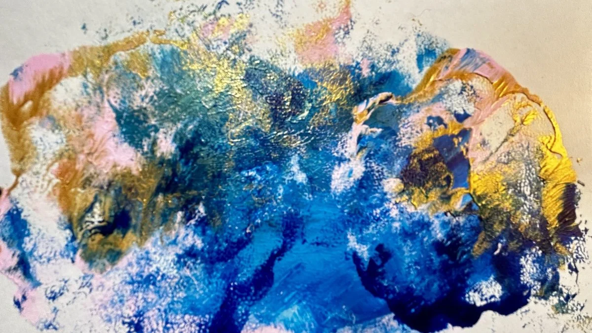 Abstract acrylic background texture featuring blended dollops of blue, metallic gold, and pink paint on a white canvas.