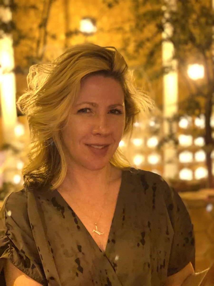 artist Heather Collis smiling in a well lit restaurant