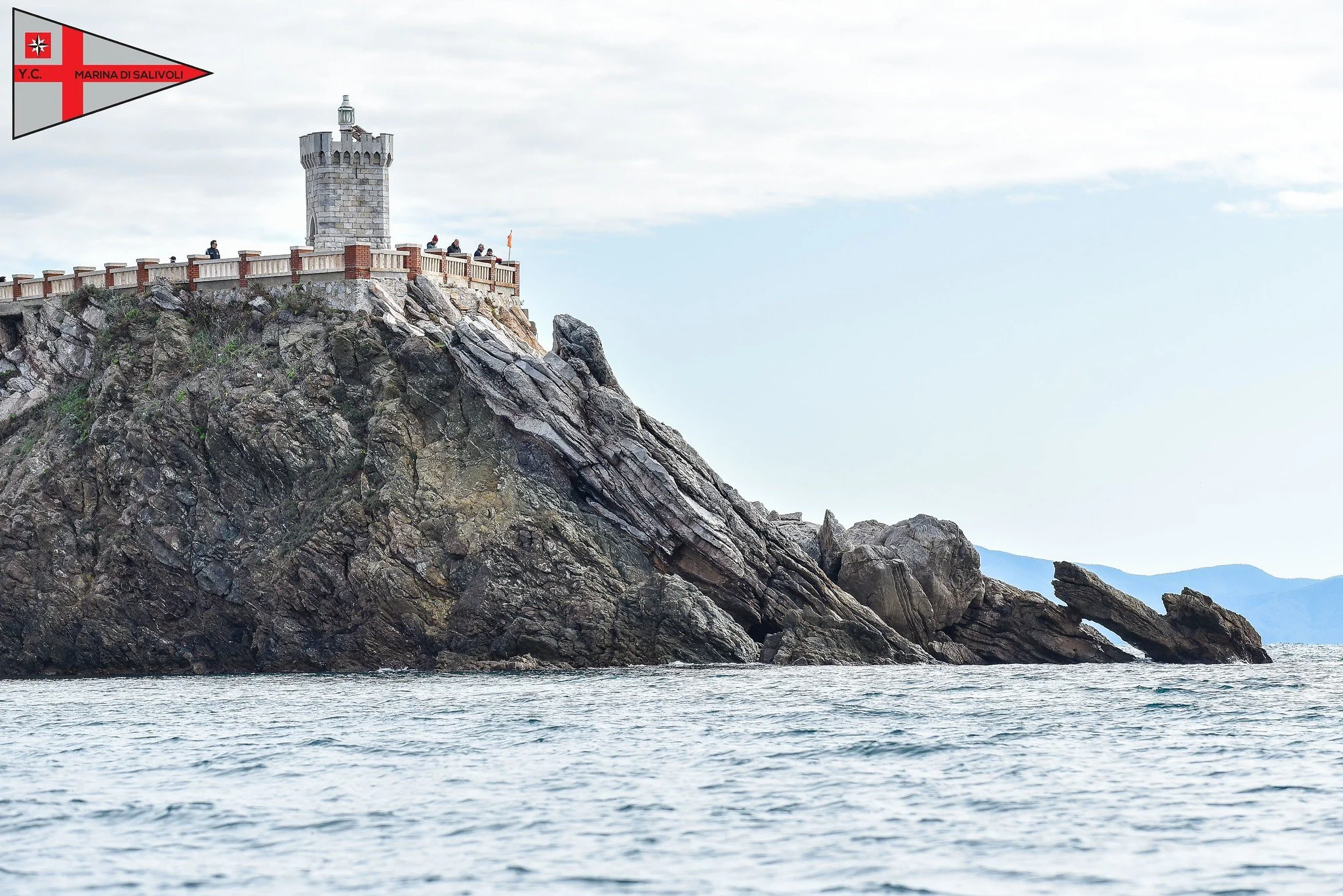Forte sulla roccia vicino al mare con veduta laterale del mare e delle montagne sullo sfondo.