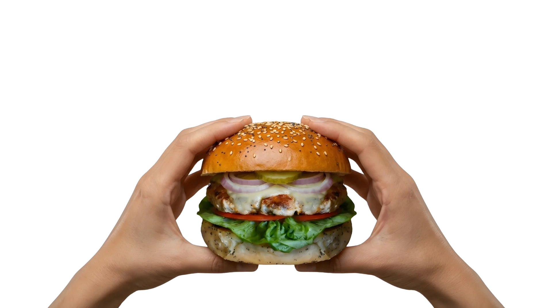 Hands holding a large burger with a sesame seed bun, lettuce, tomato and pickles at Let's Meat in Tanjung Bungah, Penang