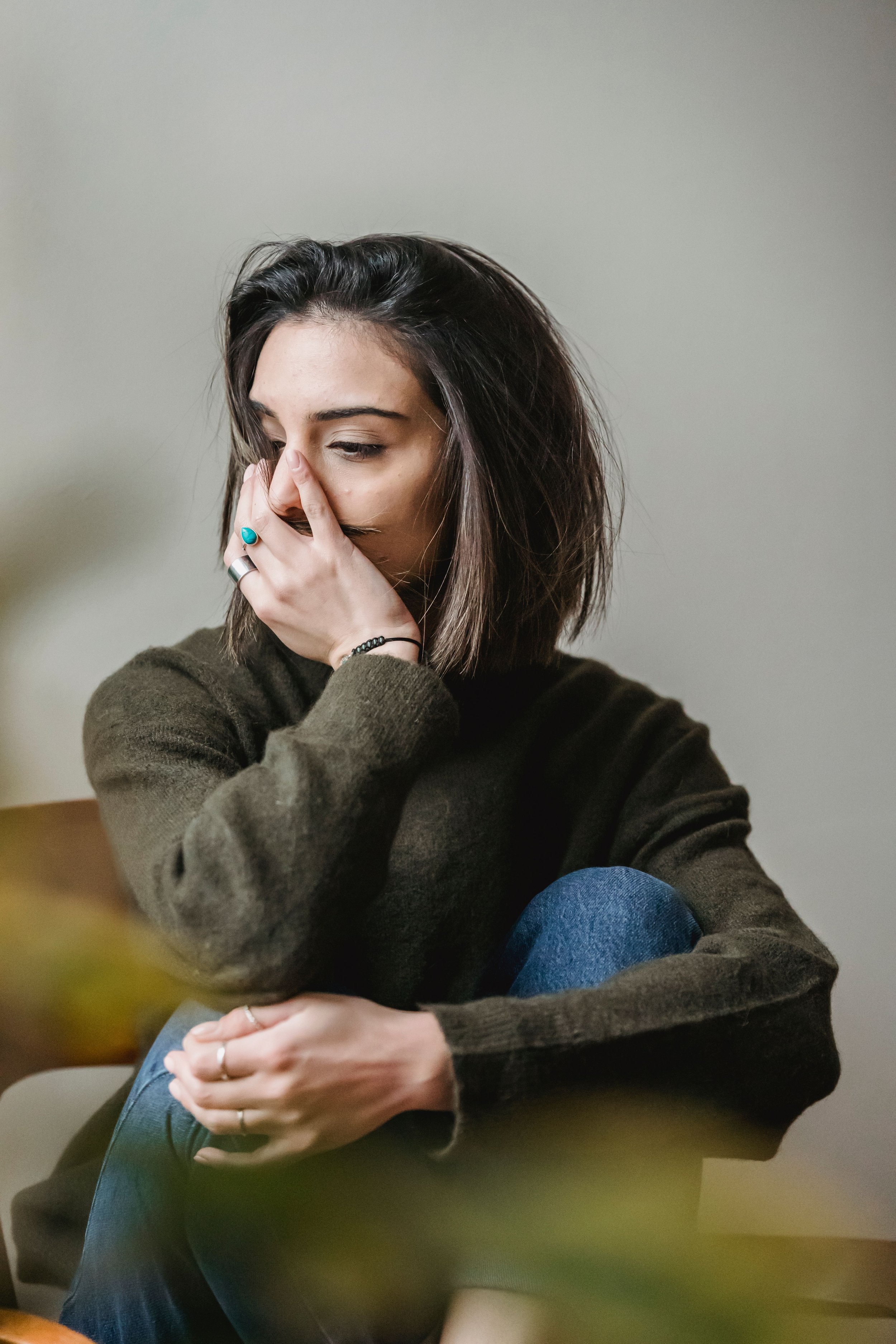 Woman holding her hand to her face, looking overwhelmed.