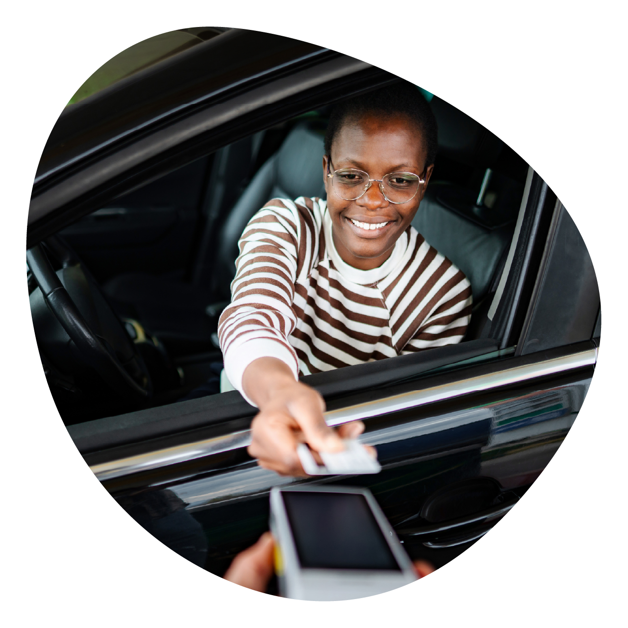 Lady in a car paying with her credit card.