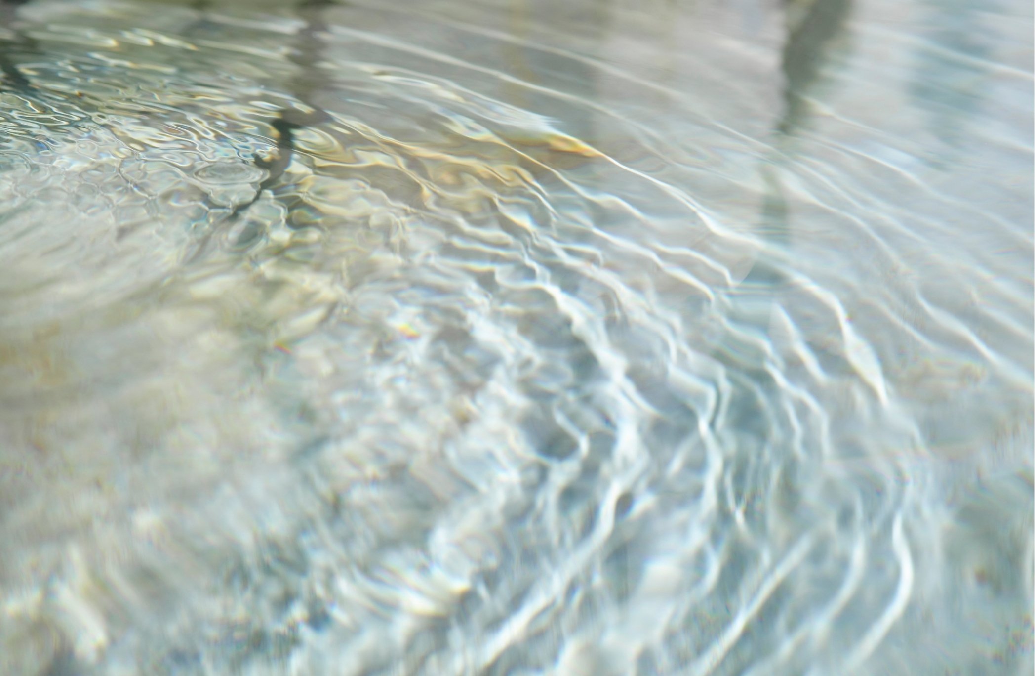Close-up of clear water with light reflections and ripples.