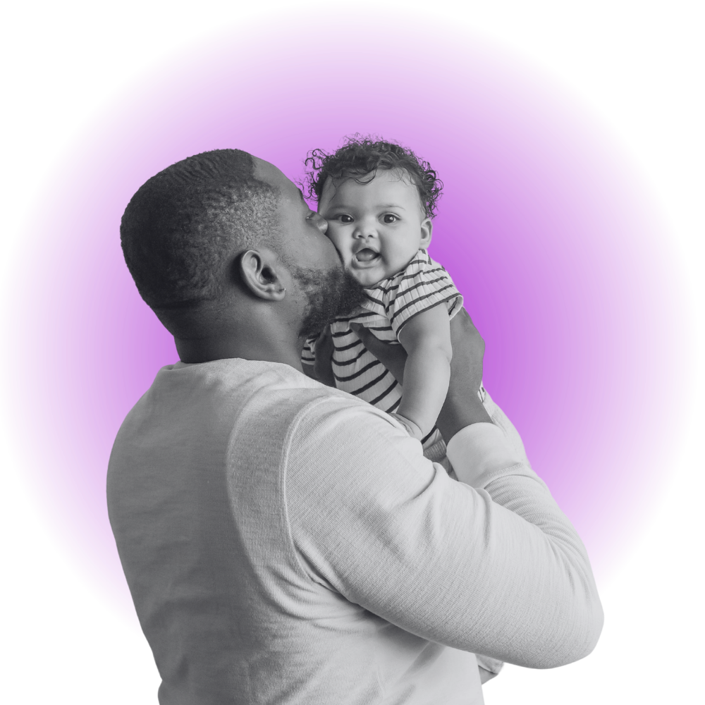 Black man holding and kissing a baby girl with curly hair, wearing a striped shirt, against a purple circular background.