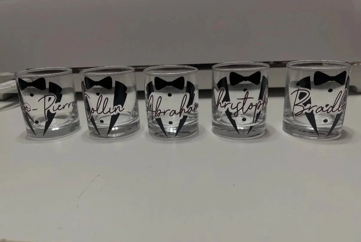 Set of five clear glass tumblers decorated with black tuxedo patterns and personalized with handwritten-style names: Pierre, Rollin, Abraham, Kristop, and Bradly.