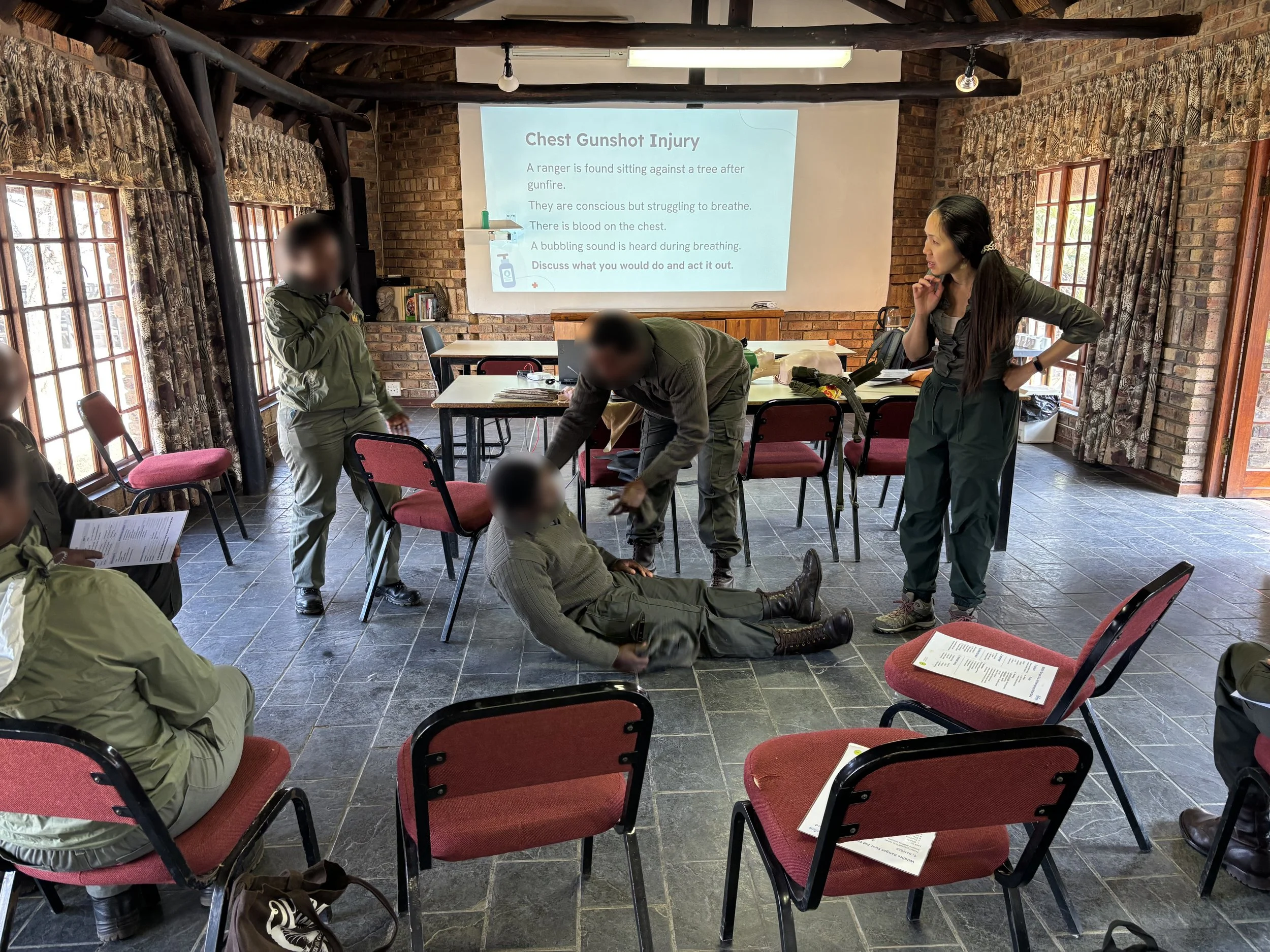 Wai-Jia conducting a first aid training session with rangers demonstrating