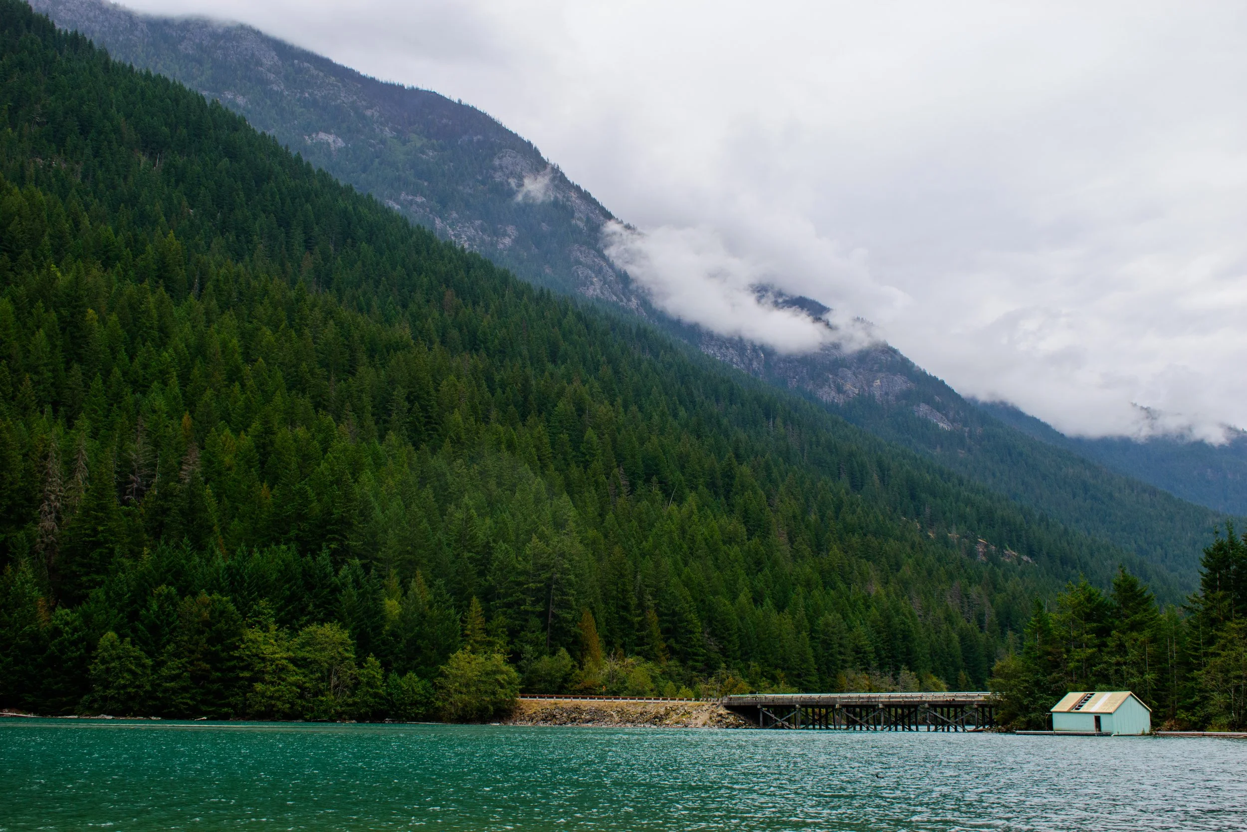 Lakeside, this home pops amongst the glacier watercolor in North Cascades National Park, Washington on a standard moody day in the PNW.