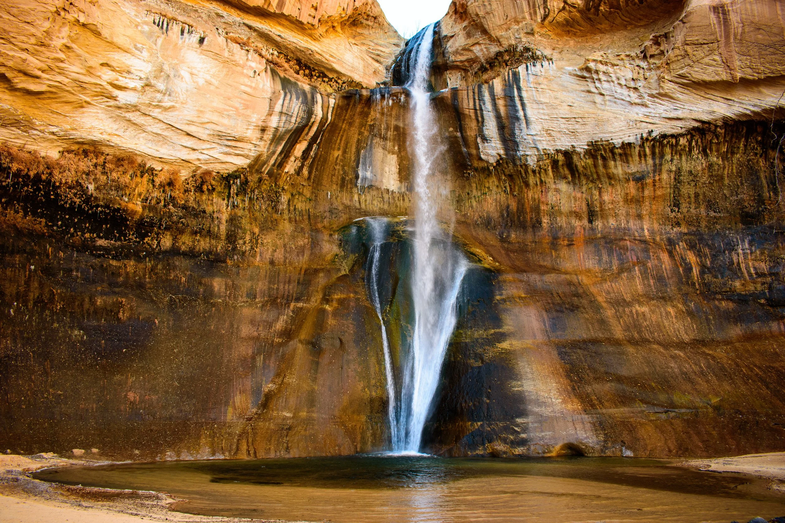 Lower Calf Creek Falls, a gorgeous waterfall tucked deep in the Escalante, Utah canyons. This 126-foot curtain of water tucked into a narrow canyon near Boulder, Utah.