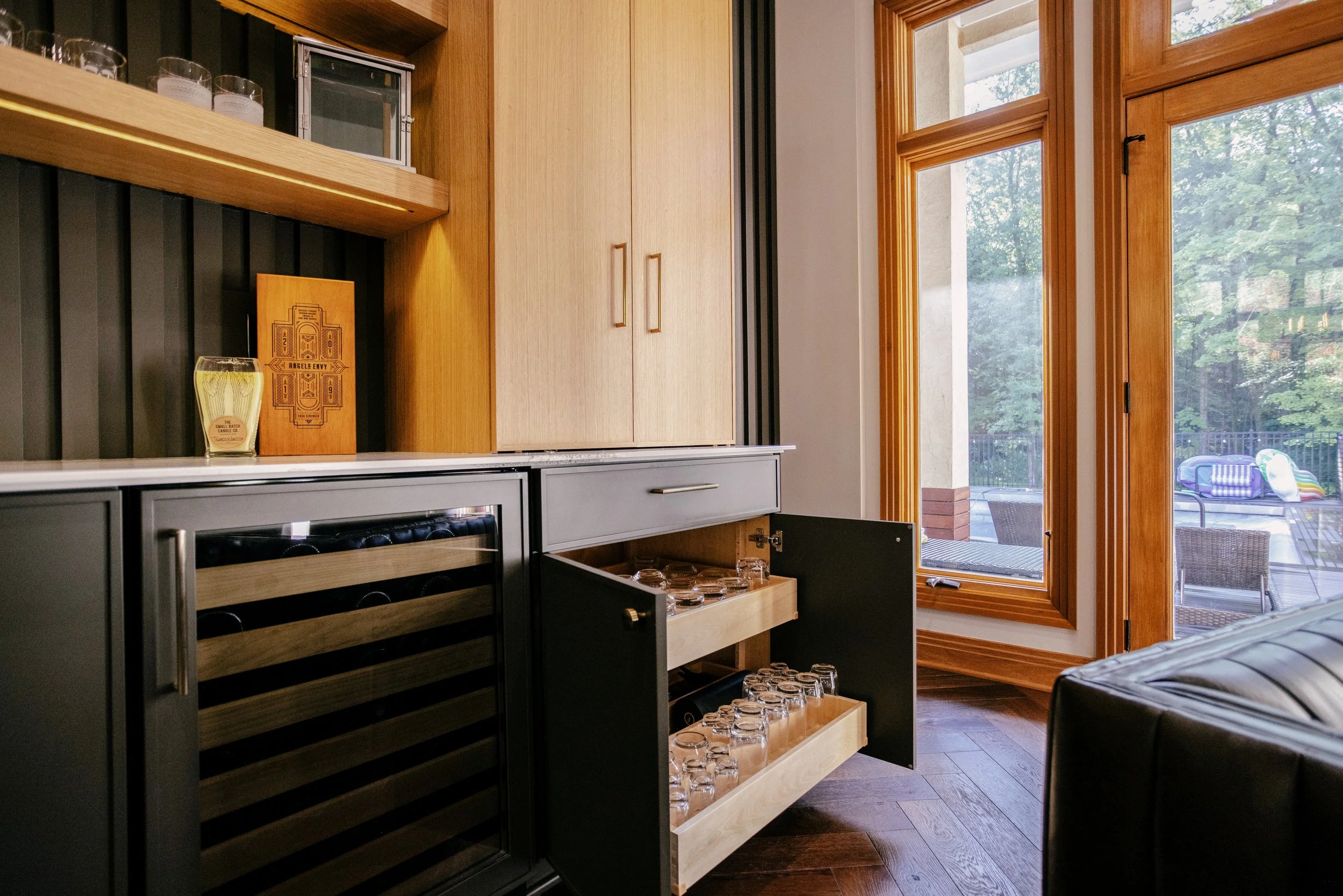 Pull out drawers sit next to an inset beverage fridge under White Oak cabinets and White Oak shelves.