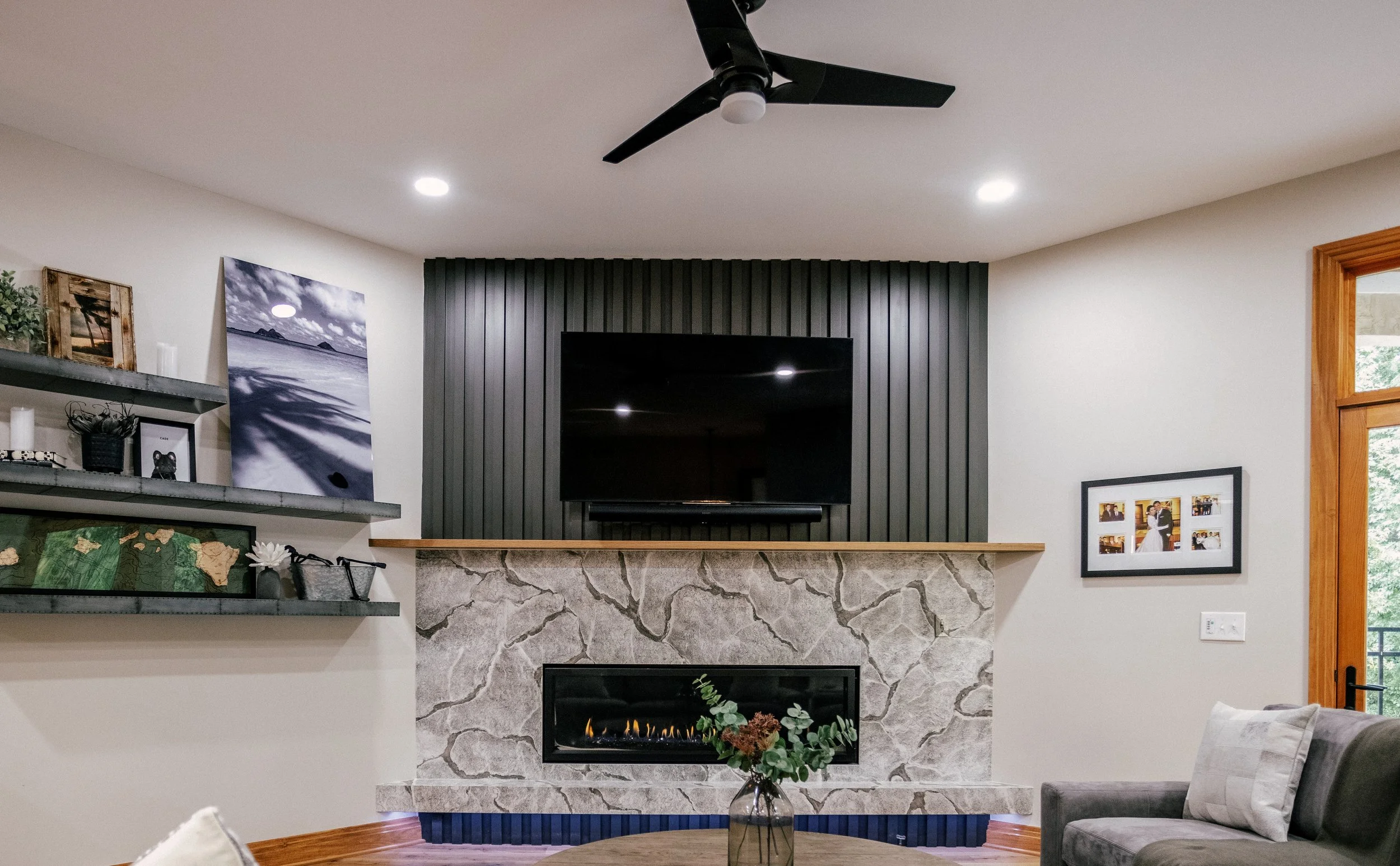 Moody slatted wall sits atop a Cambria quartz fireplace with adjustable purple underlighting.