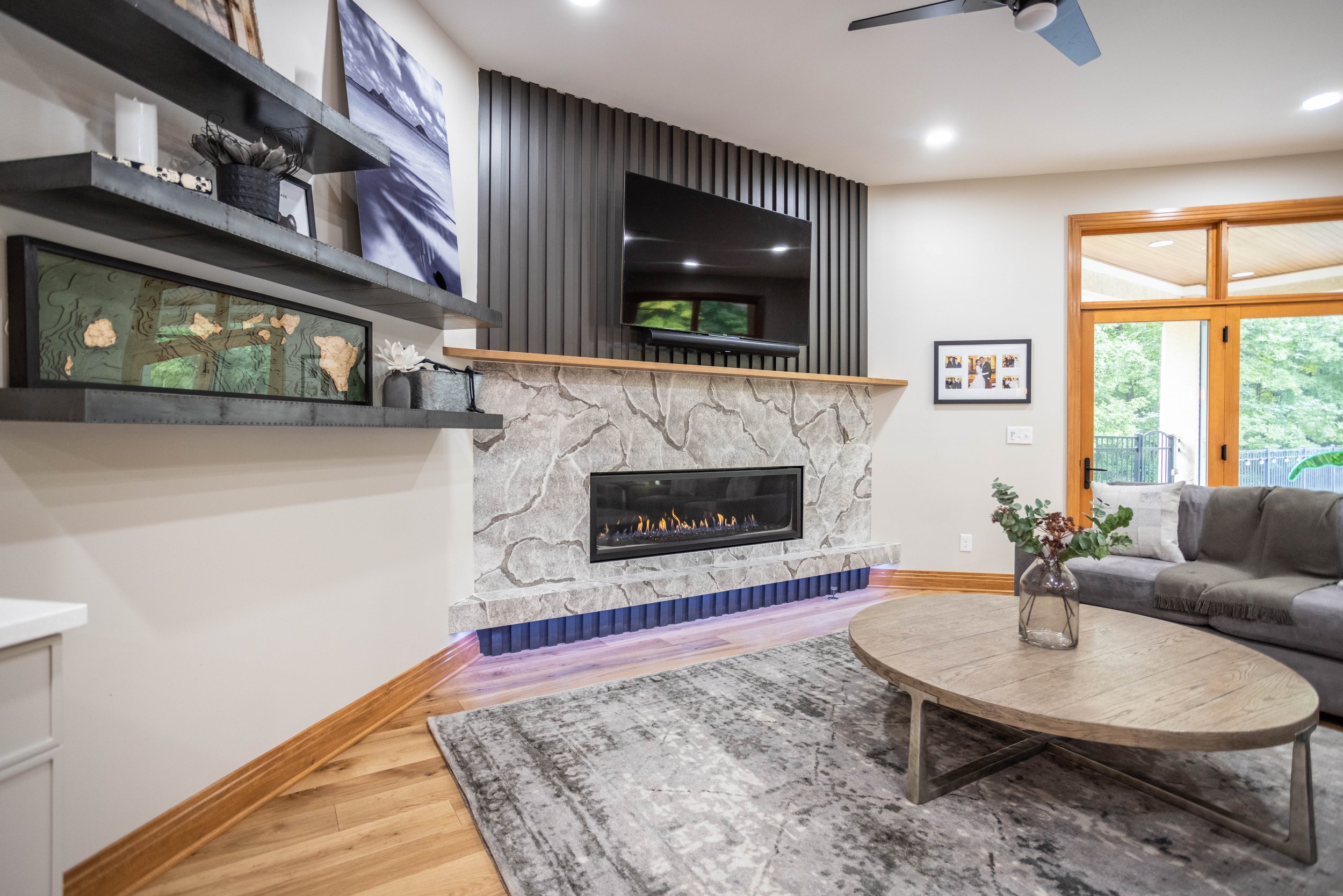 Moody slatted wall sits atop a Cambria quartz fireplace with adjustable purple underlighting.