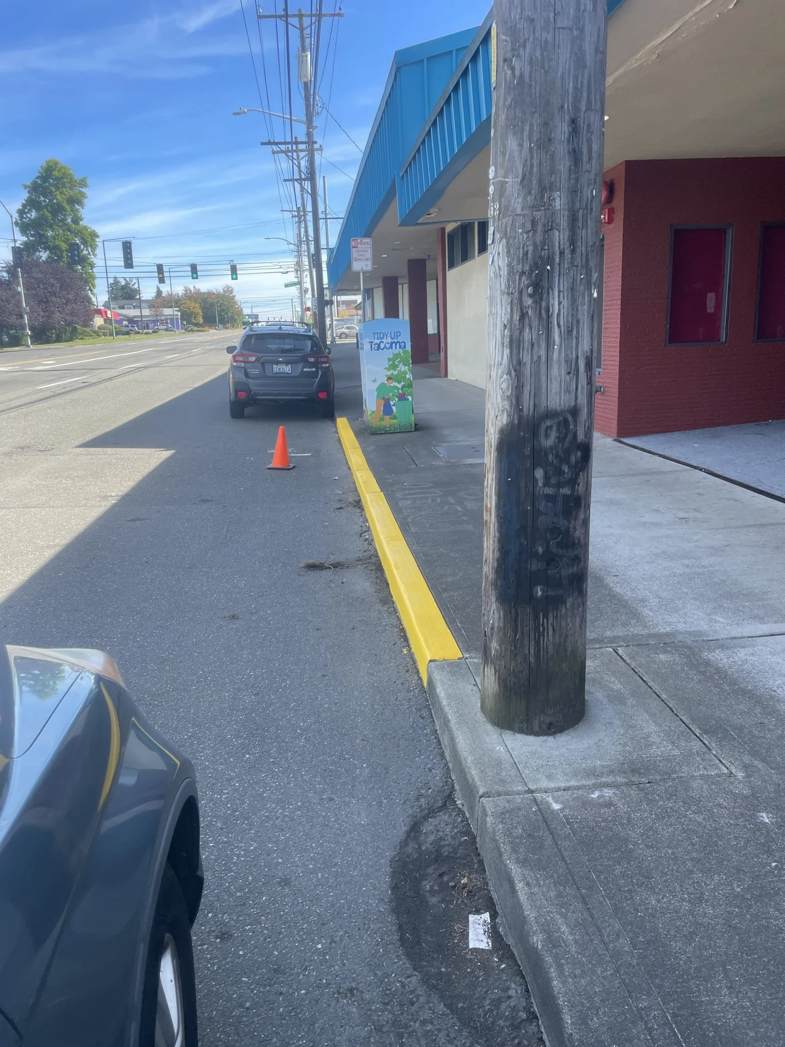 Freshly painted yellow curb along a newly sealcoated parking lot.