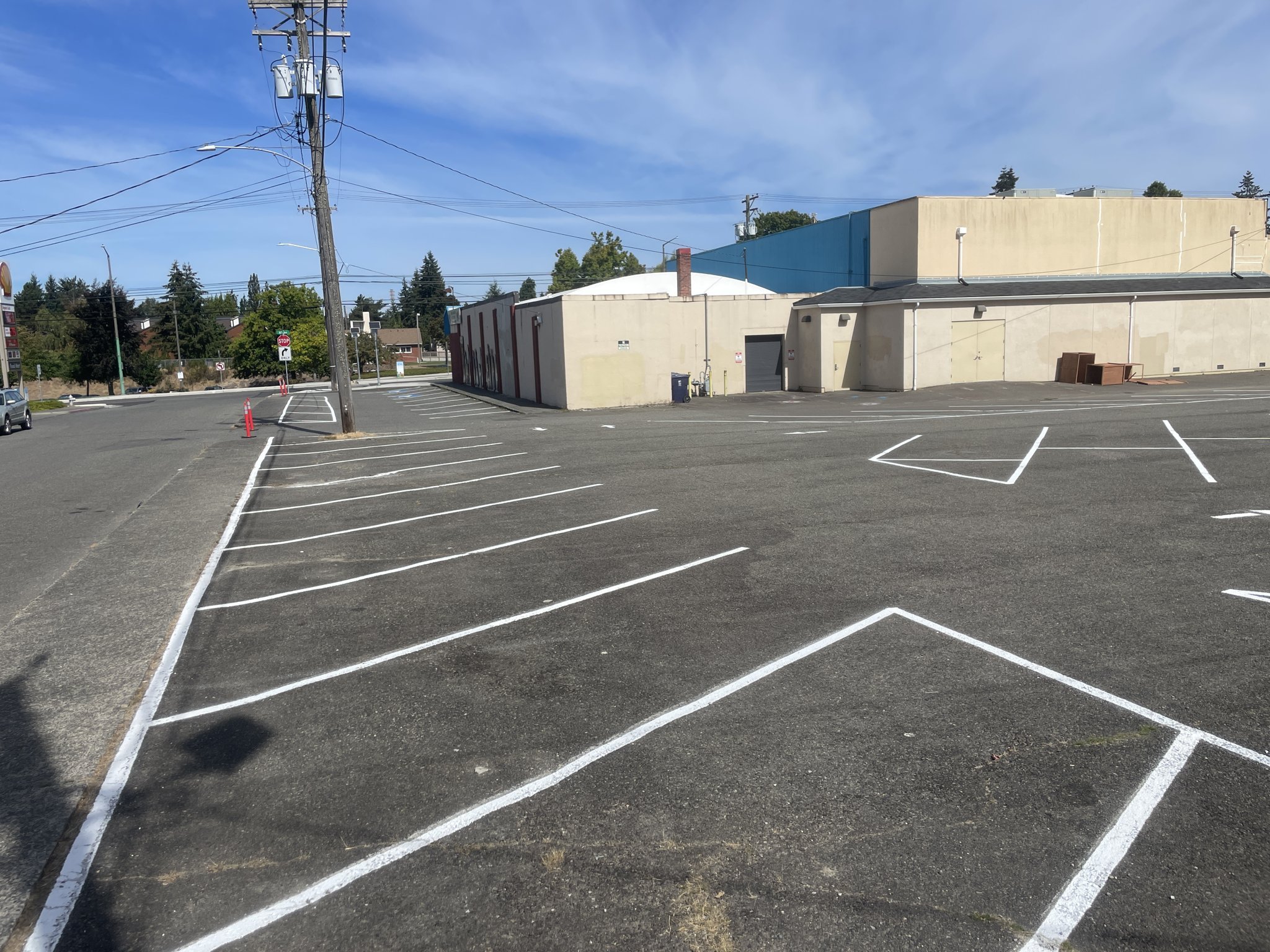 Crisp new stall lines and safety hatching across a freshly sealed lot, with the building behind.