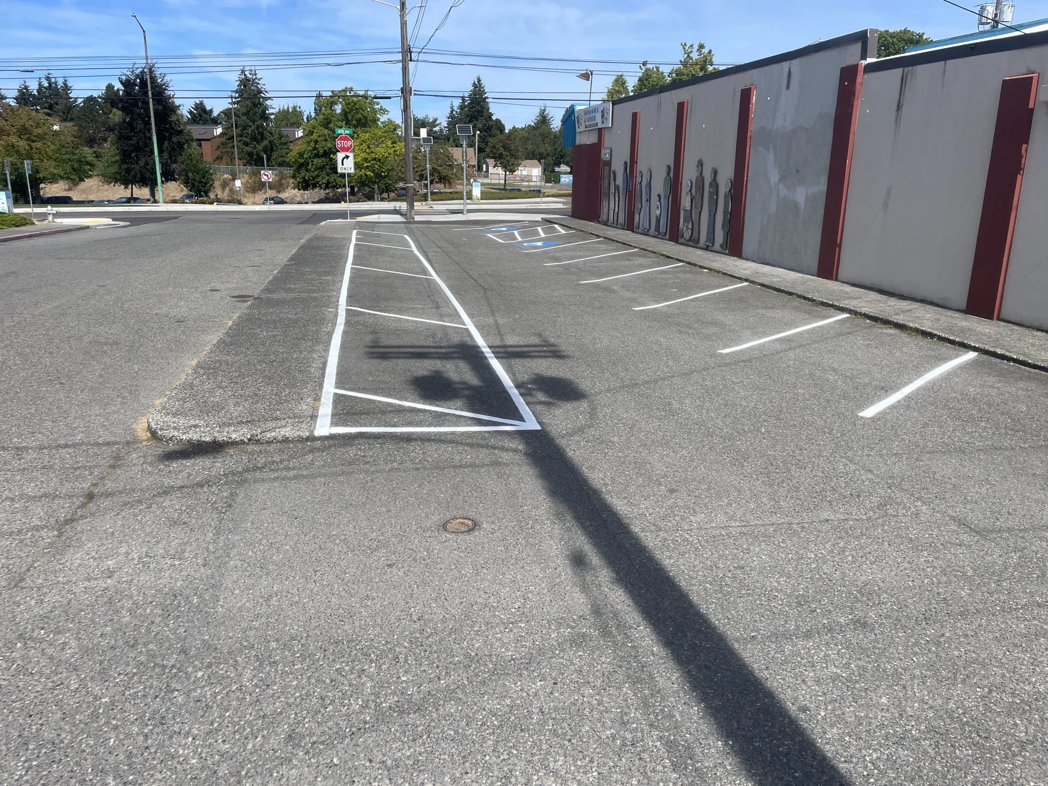 New stall lines and a hatched safety zone on a freshly sealed commercial lot.