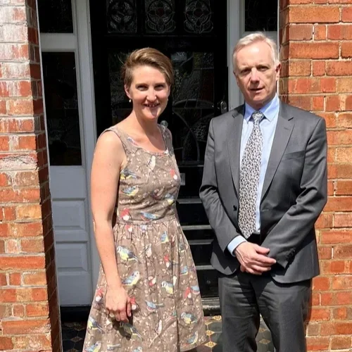 Two people standing outside a door