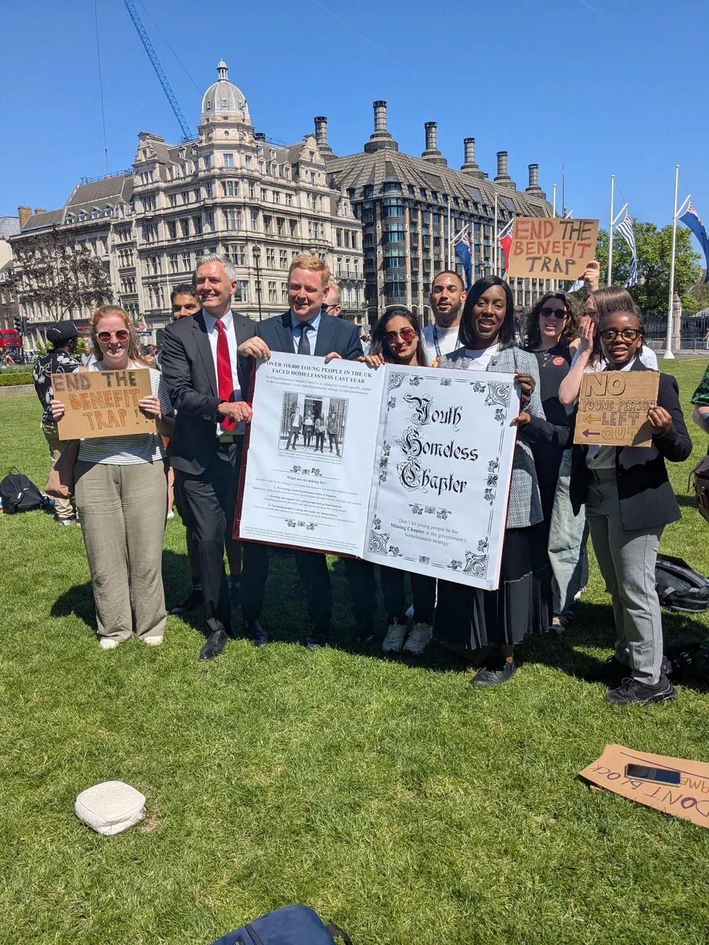 Young people and MPs holding the youth homeless chapter book prop outside parliament