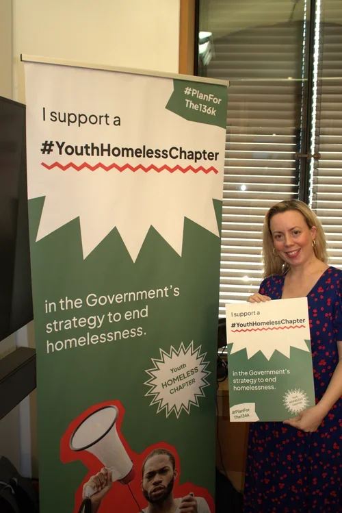 An MP holds a sign in support of the #Planforthe136K