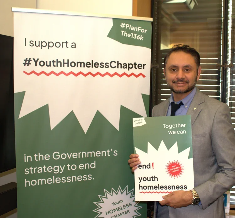Shockat Adam MP holding up a sign in support of the #Planforthe136k