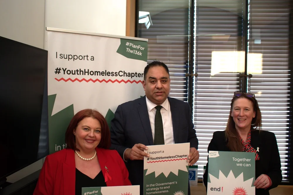 Paula Barker MP, Imran Hussain MP and another MP hold signs in support of the #Planforthe136K