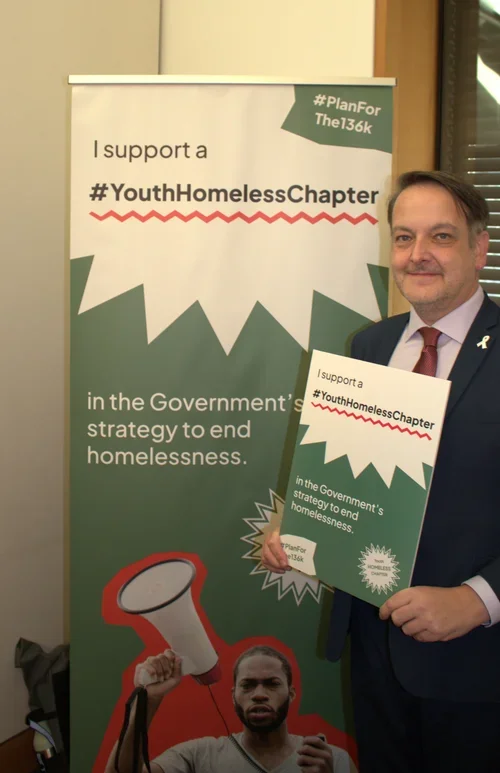 Andrew Ranger MP holds a sign in support of the #Planforthe136k