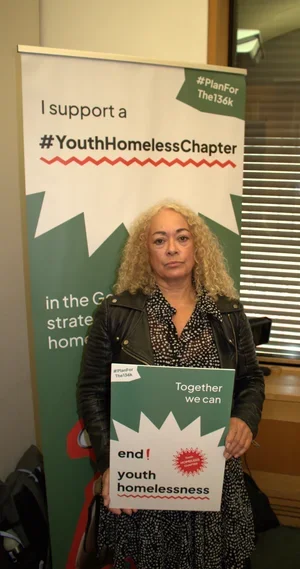 Kim Johnson MP holding a sign in support of the #Planforthe136K