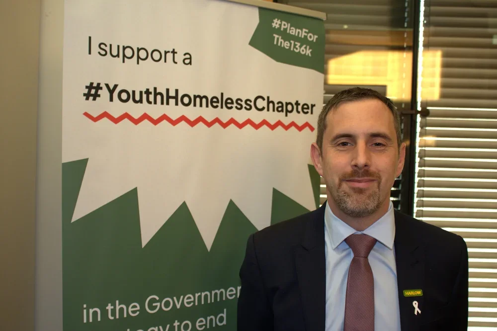 Chris Vince MP standing in front of a banner in support of the #Planforthe136K
