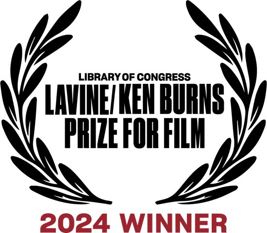 Award medal with engraved text and a maroon ribbon reading Ken Burns Prize for Film '2024 WINNER'.