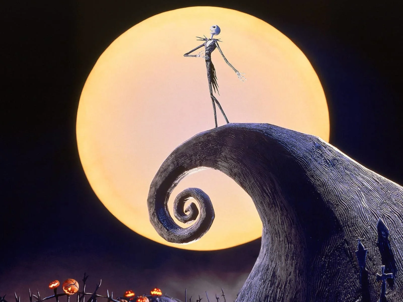 Nighttime scene from The Nightmare Before Christmas with Jack Skellington standing on a spiral hilltop against a large, glowing yellow moon, with a row of lit pumpkins at the bottom.