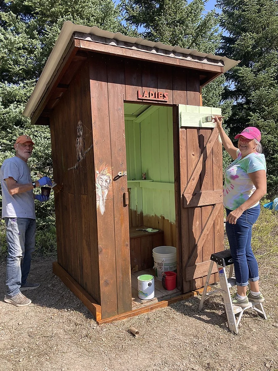 Annie and Trace painting the outhouse