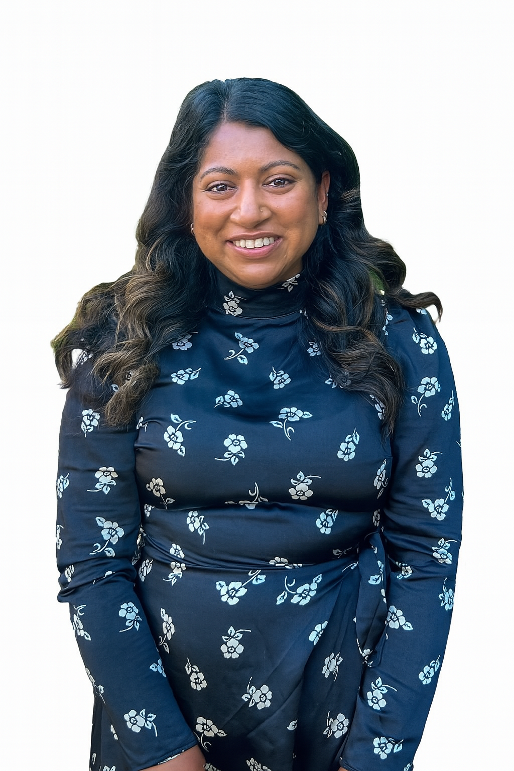 A woman with long dark hair smiling, wearing a navy blue dress with a floral pattern, against a white background.